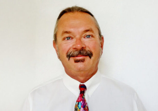 Mike Cazabon portrait wearing white shirt and colorful tie